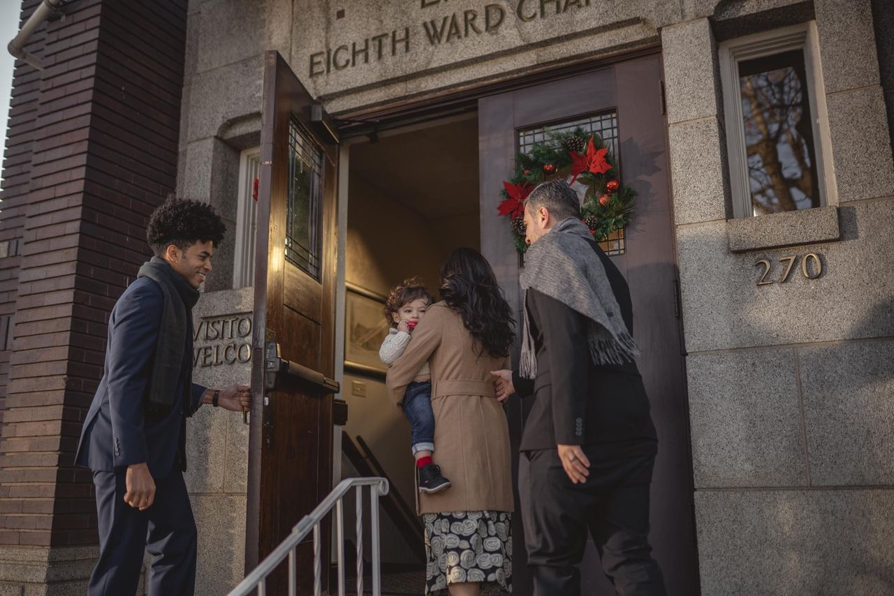 Young man opens church door for family